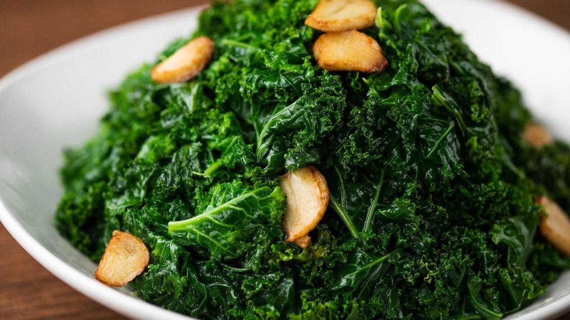 Sauteed Kale with Garlic on a white plate, close up