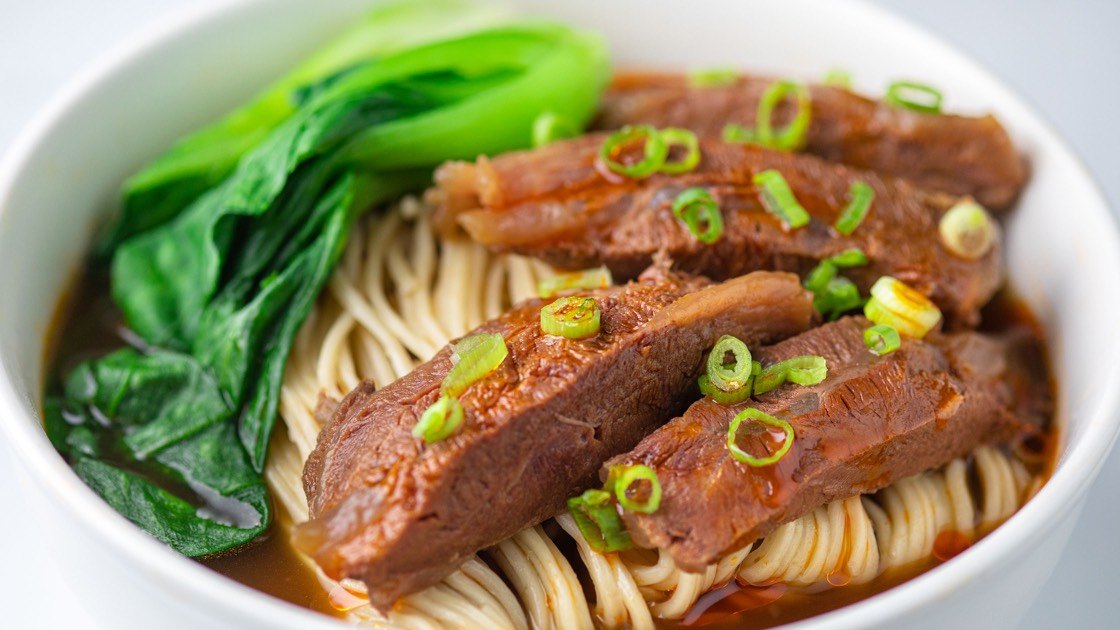 Braised Beef Noodle Soup in a white bowl, close up