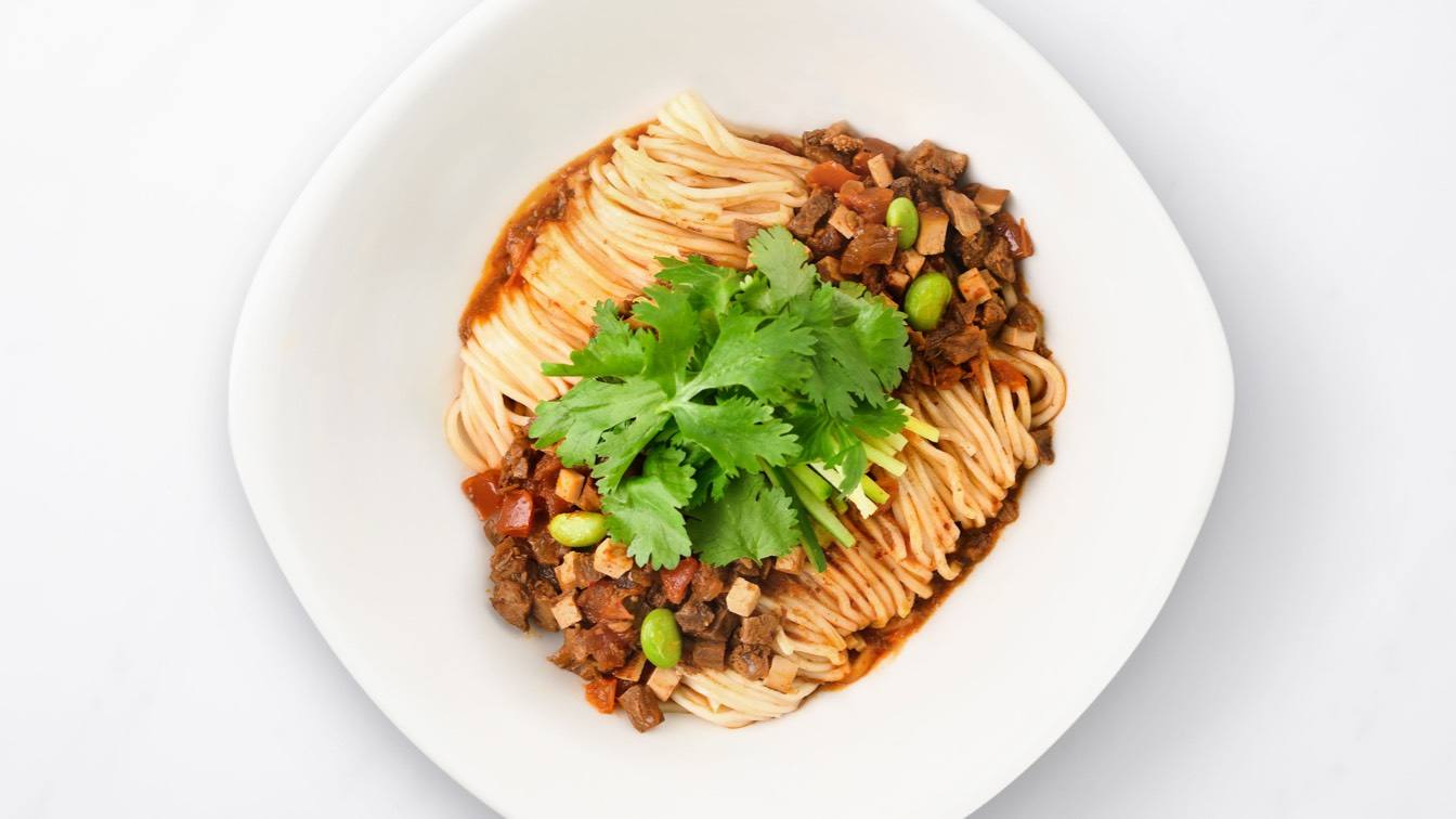 Noodles with Diced Beef & Szechuan Peppers in a white bowl