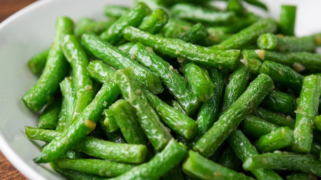 Sauteed String Beans with Garlic in a white dish, close up