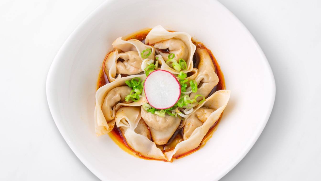 Jidori Chicken Wontons with Spicy Sauce in a white bowl
