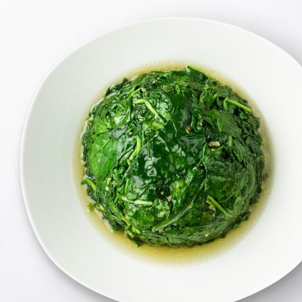Round of sauteed Spinach with Garlic in a white dish