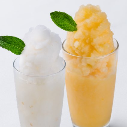 A photo of two glasses of lychee slush and mango slush side-by-side