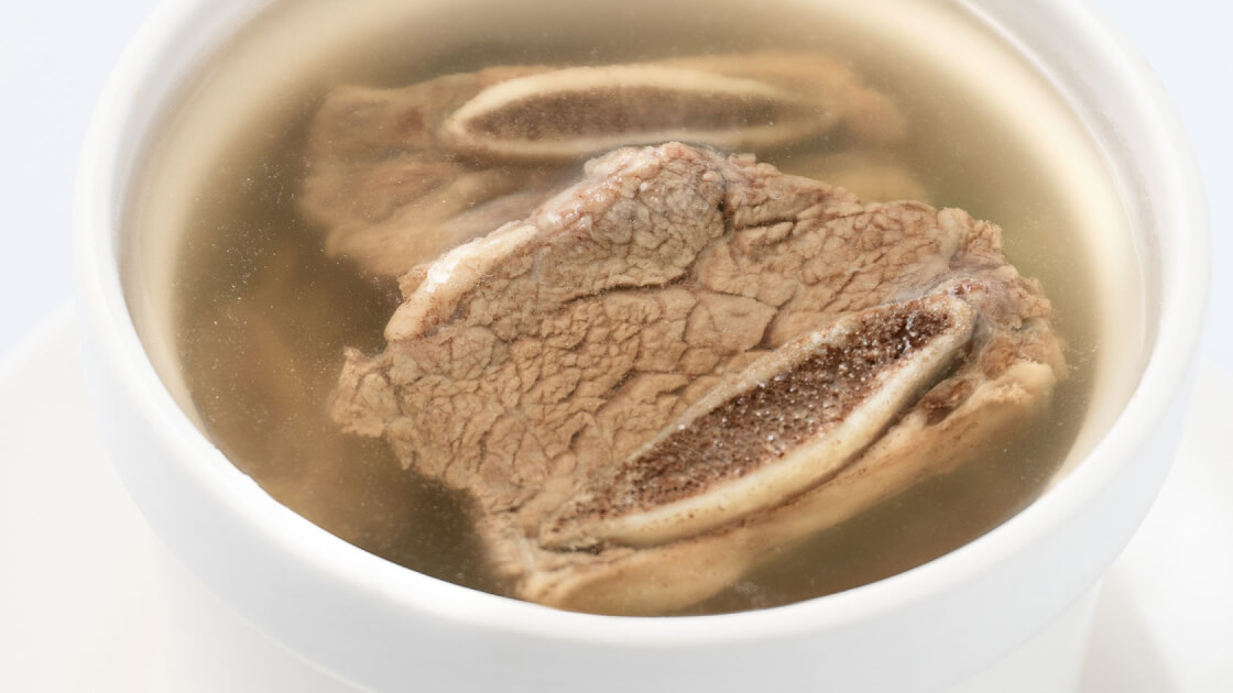 House Beef Soup (Steamed) in a white bowl, close up